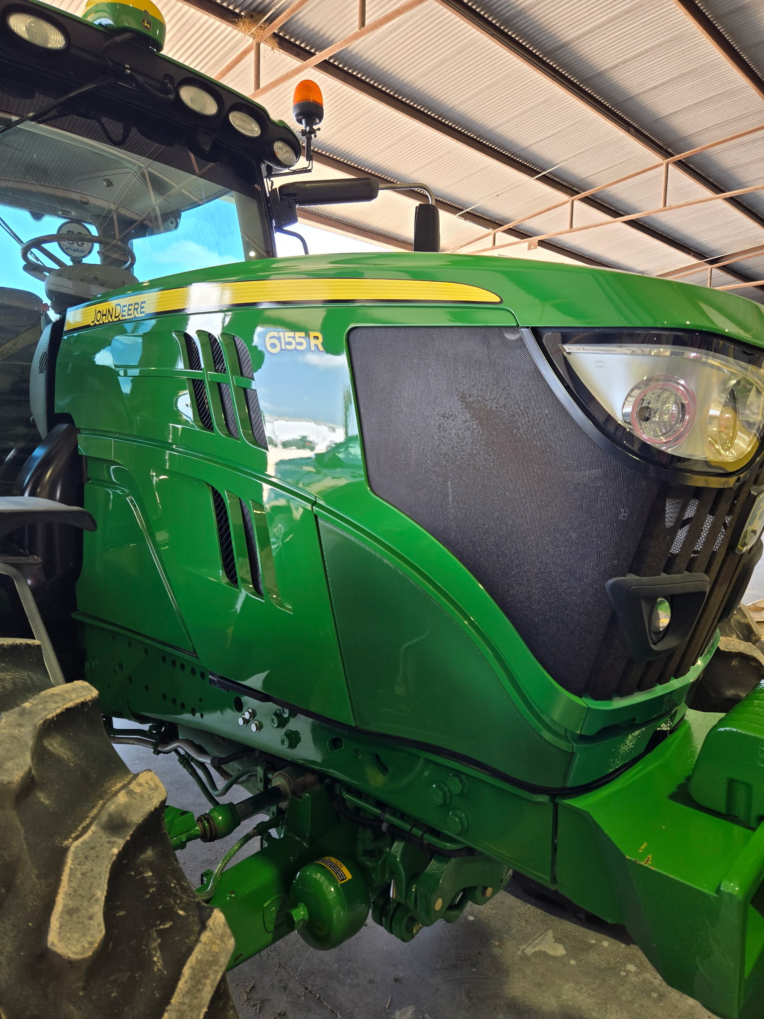 Green John Deere 6155R tractor after exterior polishing and detailing
